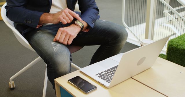 Businessman Checking Smartwatch While Working on Laptop - Download Free Stock Images Pikwizard.com