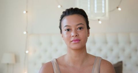Relaxed Woman in Cozy Bedroom with Ambient String Lights