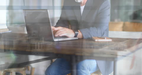 Senior Businessman Using Laptop in Modern Office Setting