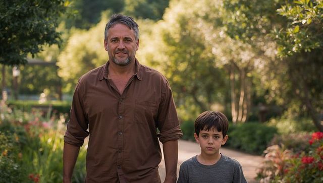 Father and son walking along sunlit garden path, casual family bonding outdoors