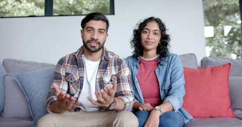 Relaxed Asian Couple Sitting on Sofa in Bright Living Room