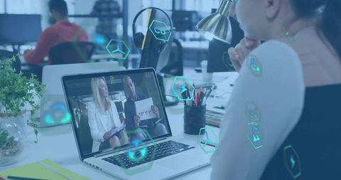 Watching Virtual Presentation on Laptop in Open Office with Futuristic Data Overlays