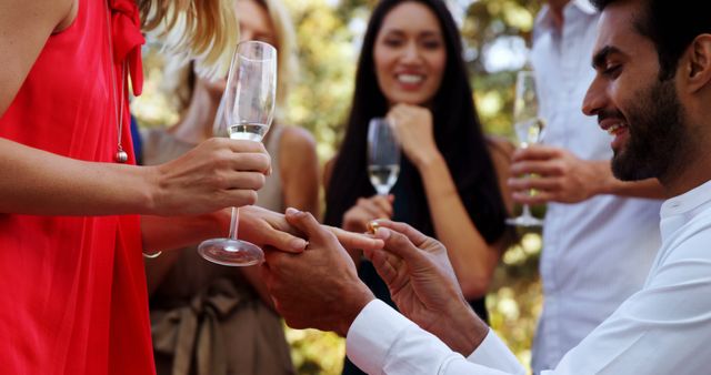 Man Proposing to Woman in Outdoor Celebration with Friends - Download Free Stock Images Pikwizard.com