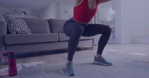 Determined woman practicing squats in cozy home environment