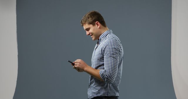 Man Engaged with Smartphone in Studio Background - Download Free Stock Images Pikwizard.com