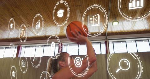 Female athlete shooting basketball in indoor court with digital coaching icons overlay