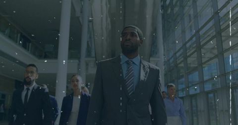 Confident business leader leading team through glass lobby