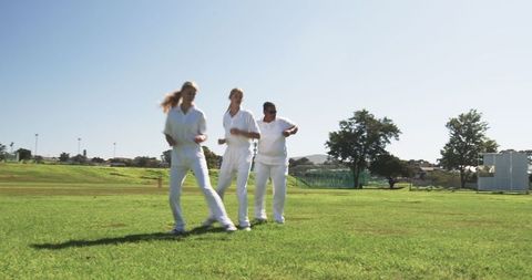 Female Cricket Team Engaged in Drills Under Clear Sky
