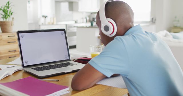 Image of focused african american boy with laptop with copy space having online lessons at home. Childhood, education and education from home concept.