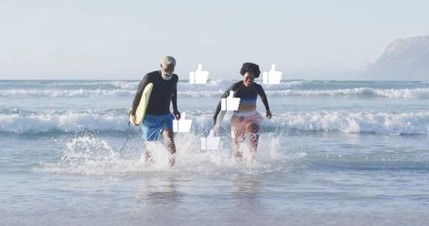 Active seniors running with surfboard in ocean