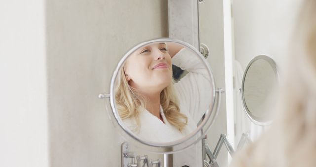 Happy young woman smiling at bathroom mirror enjoying self-care routine - Download Free Stock Images Pikwizard.com