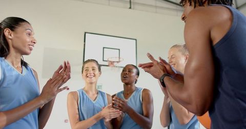 Diverse female basketball team in motivational huddle