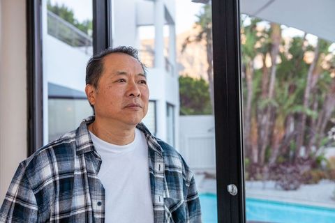 Man relaxing at modern home overlooking poolside serenity