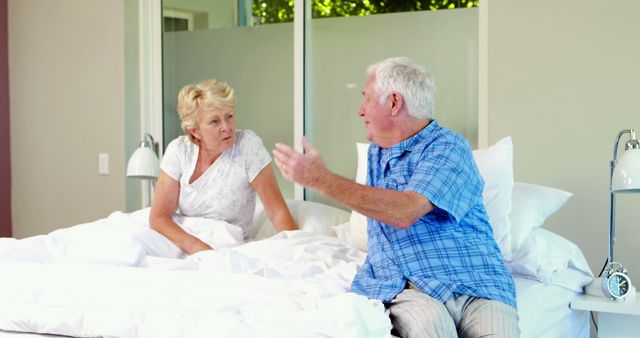 Senior Couple Having a Conversation While Sitting on Bed in Mundane Attire - Download Free Stock Images Pikwizard.com