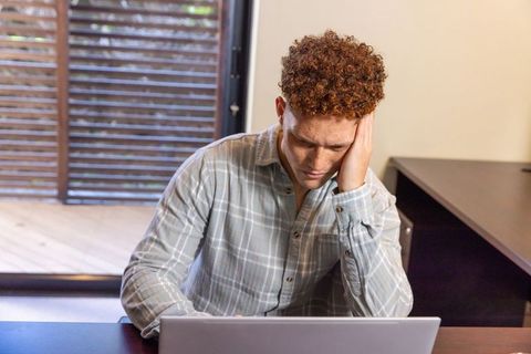 Man Focused on Laptop in Home Office