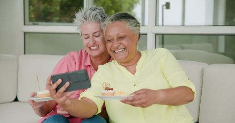 Senior Couple Celebrating Birthday with Selfie and Cake Indoors