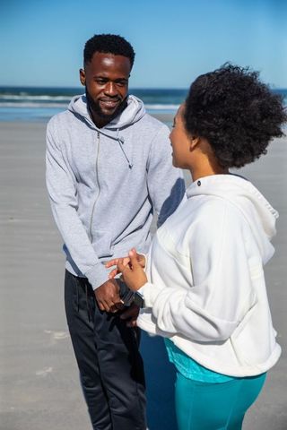 Couple Conversing on Beach in Casual Activewear