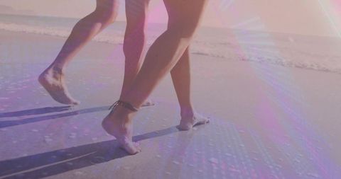 Walking barefoot on pastel beach couple leaving footprints sunlit coastal romance