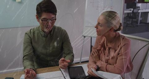 Colleagues discussing data and reports in modern office meeting with tablet and charts