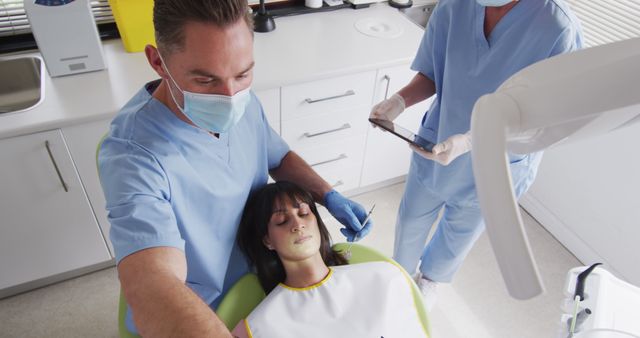 Dentist Treating Patient with Nurse Assisting in Modern Dental Clinic - Download Free Stock Images Pikwizard.com