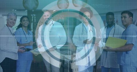 Diverse medical team standing in clinic lobby with charts and tablets and digital overlay