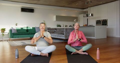 Senior Couple Practicing Yoga in Modern Living Room for Relaxation