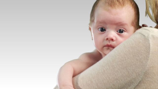 Features a young newborn baby resting on mother's shoulder, looking curiously at the camera. Ideal for parenting blogs, family health magazines, maternity websites, and any content related to motherhood, infant care, and family love. Emphasizes the tender bond between mother and baby, perfect for themes on parental connection and care.