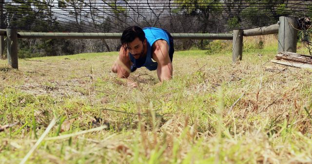 Athletic Man Crawling Through Obstacle Course on Grass - Download Free Stock Images Pikwizard.com