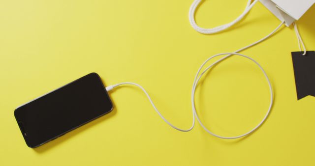 Smartphone Charging with Long Cable on Bright Yellow Background - Download Free Stock Images Pikwizard.com