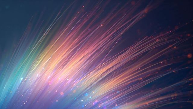 Colorful fiber-optic light streaks radiating neon gradient with glowing bokeh particles
