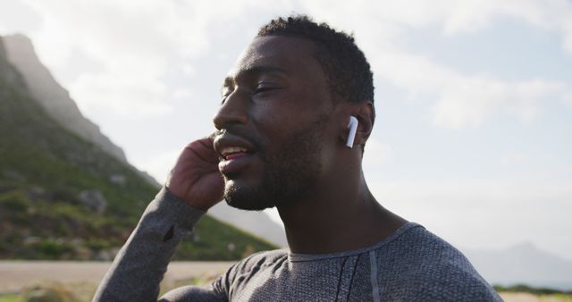 Male Jogger Wearing Wireless Earbuds Outdoors on Sunny Day - Download Free Stock Images Pikwizard.com