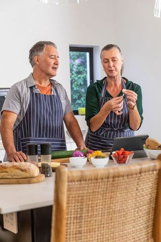 Senior couple in modern kitchen preparing meal together