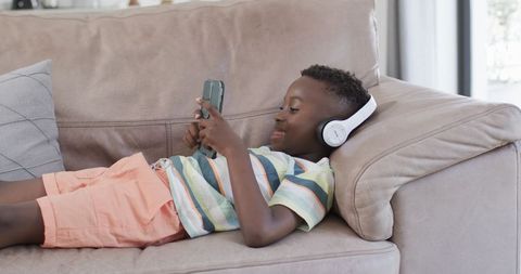 Boy Relaxing with Headphones and Smartphone on Couch