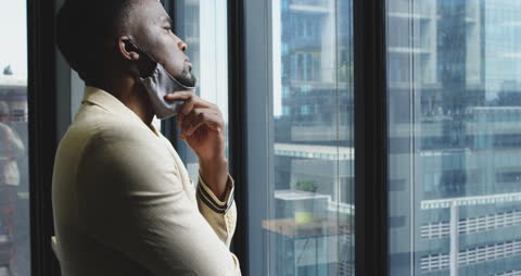 Pensive Businessman Looking Out Office Window During Pandemic