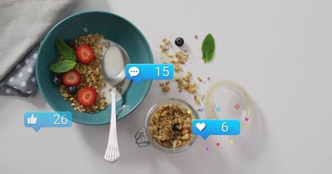 Showing top-down teal bowl with granola, yogurt, berries and social media icons