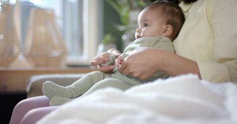 Mother and Infant Enjoying Peaceful Time by Window, Daylight in Living Room