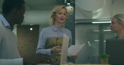 Diverse Team Analyzing Business Data in Modern Industrial Office