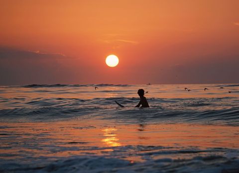 Surfer enjoying serene sunset beach waves