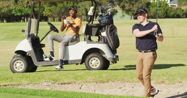 Image of diverse male friends playing golf on golf field. sporty, active lifestyle and playing golf concept.