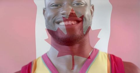 Smiling athlete wearing yellow jersey with canadian maple leaf overlay, pastel pink
