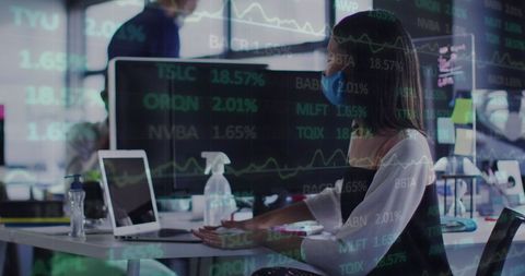 Businesswoman Analyzing Stock Market Data on Laptop in Office