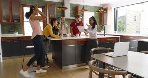 Diverse Friends Gathering Around Kitchen Island Reacting to Surprise Letter with Coffee