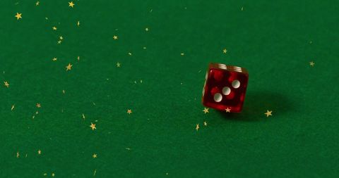 Red Dice Amid Sparkling Stars on Green Surface