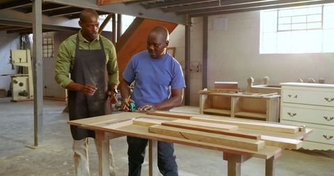 Carpenters collaborating in workshop on joinery