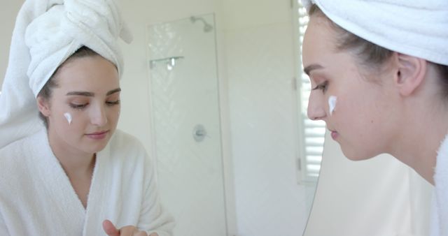 Woman in Bathroom Applying Skincare Cream Using Mirror Reflection - Download Free Stock Images Pikwizard.com