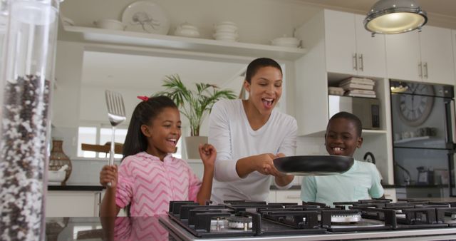 Happy mother cooking with children in kitchen - Download Free Stock Images Pikwizard.com