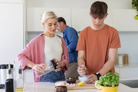Multigenerational family preparing healthy meal together in bright contemporary kitchen