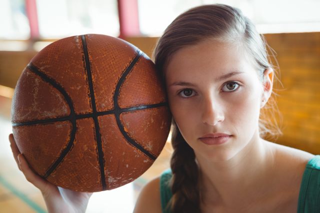Close up portrait of female basketball player with ball in court
