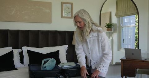 Elegant Woman Preparing for a Trip in Stylish Bedroom