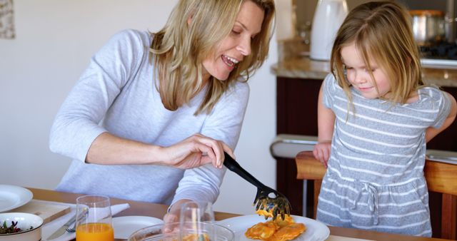 Mother Serving Pasta to Daughter at Breakfast Table - Download Free Stock Images Pikwizard.com